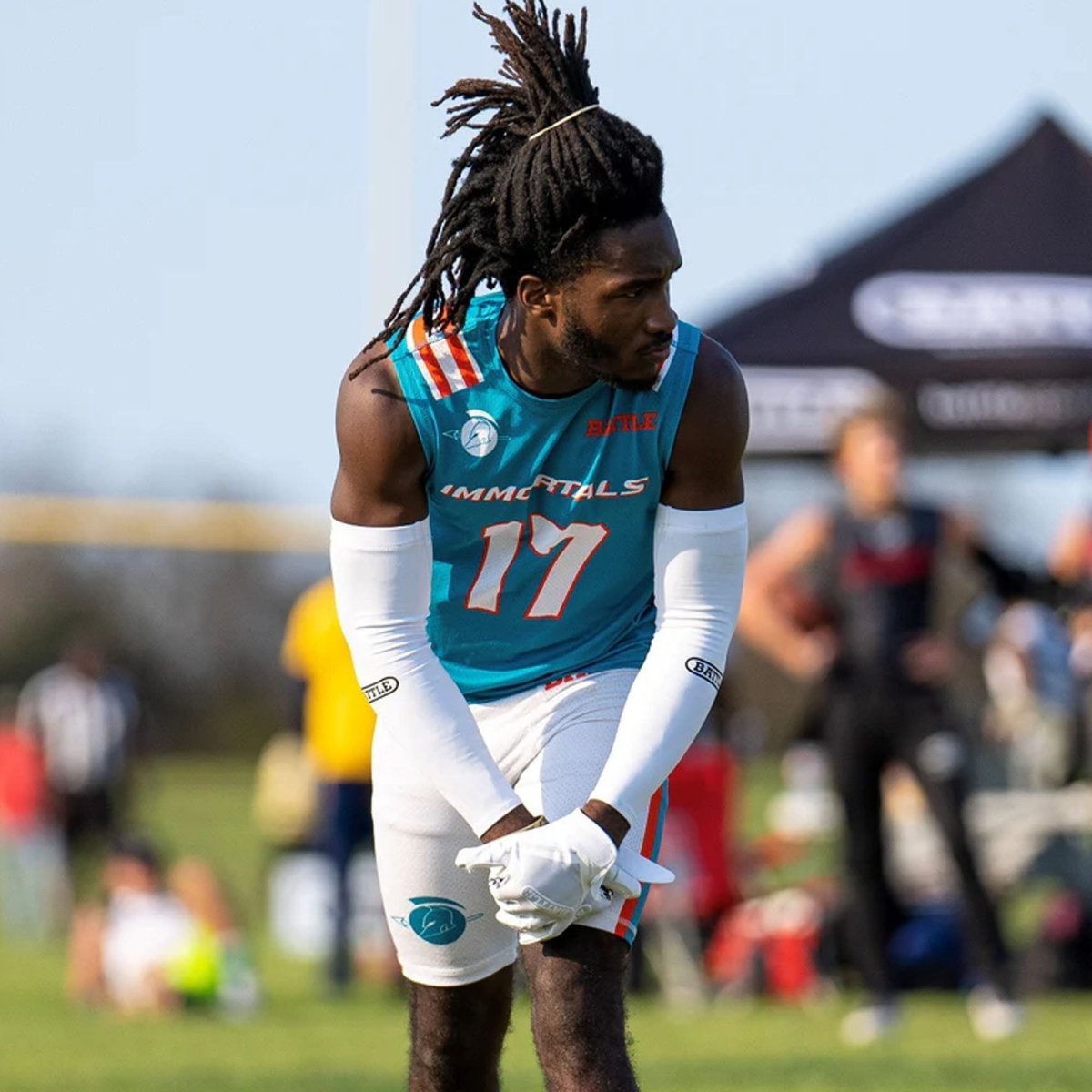 Person wearing a sports jersey with number 17 and football full arm sleeves on a field