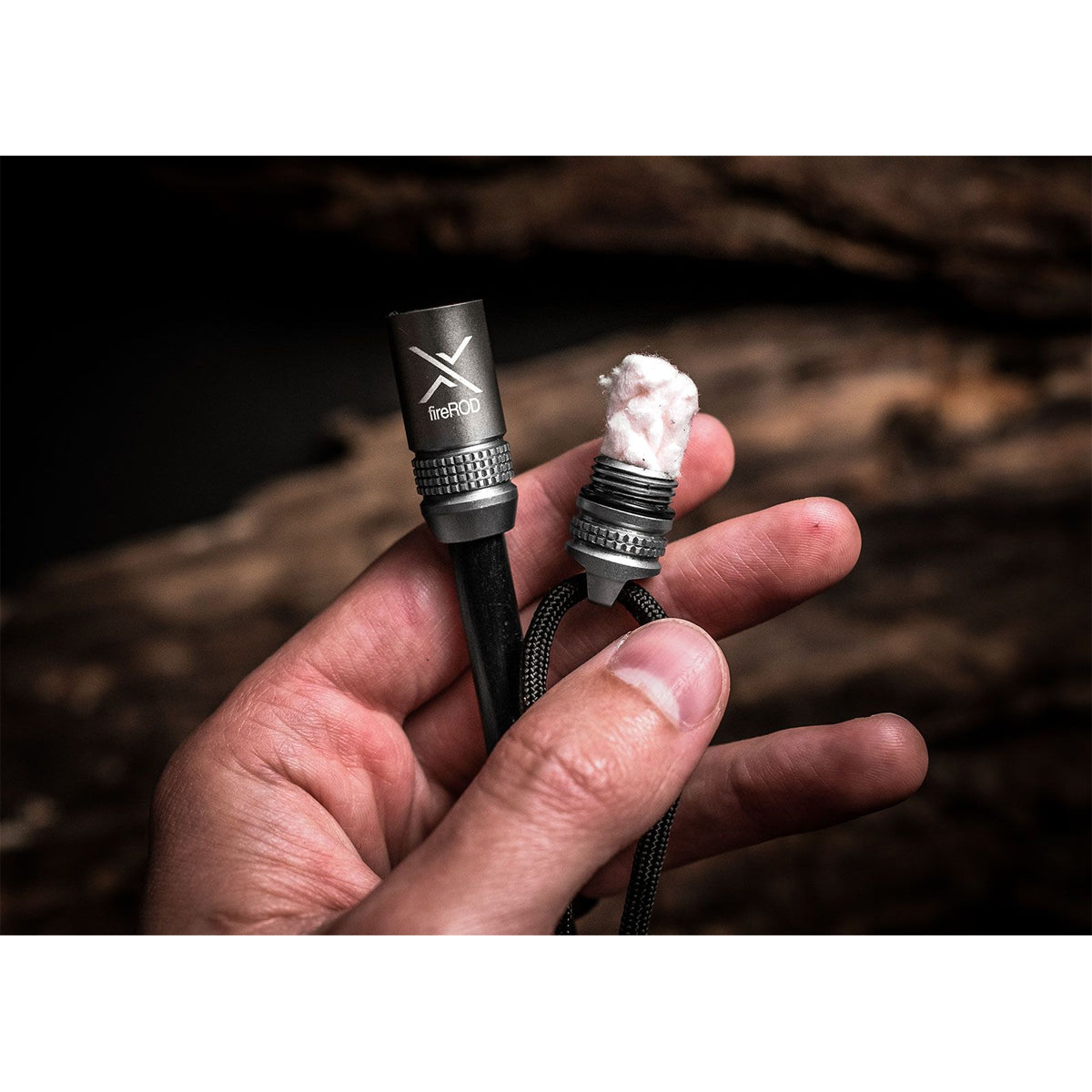 Hand holding a fire starter device with a dark background
