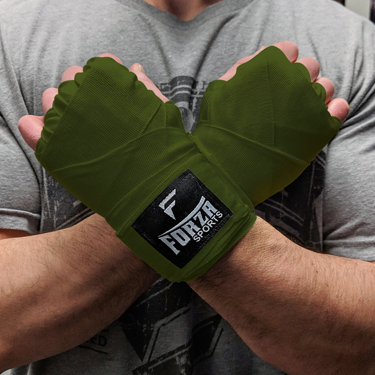 Green wrist wraps with Forza Sports logo on a person wearing a gray shirt.