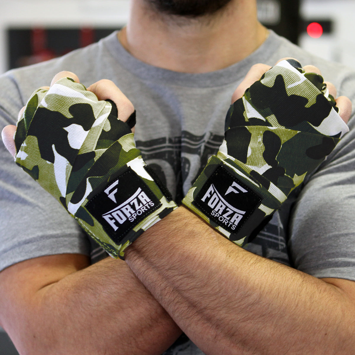 Person wearing camouflage boxing hand wraps with Forza Sports logo.