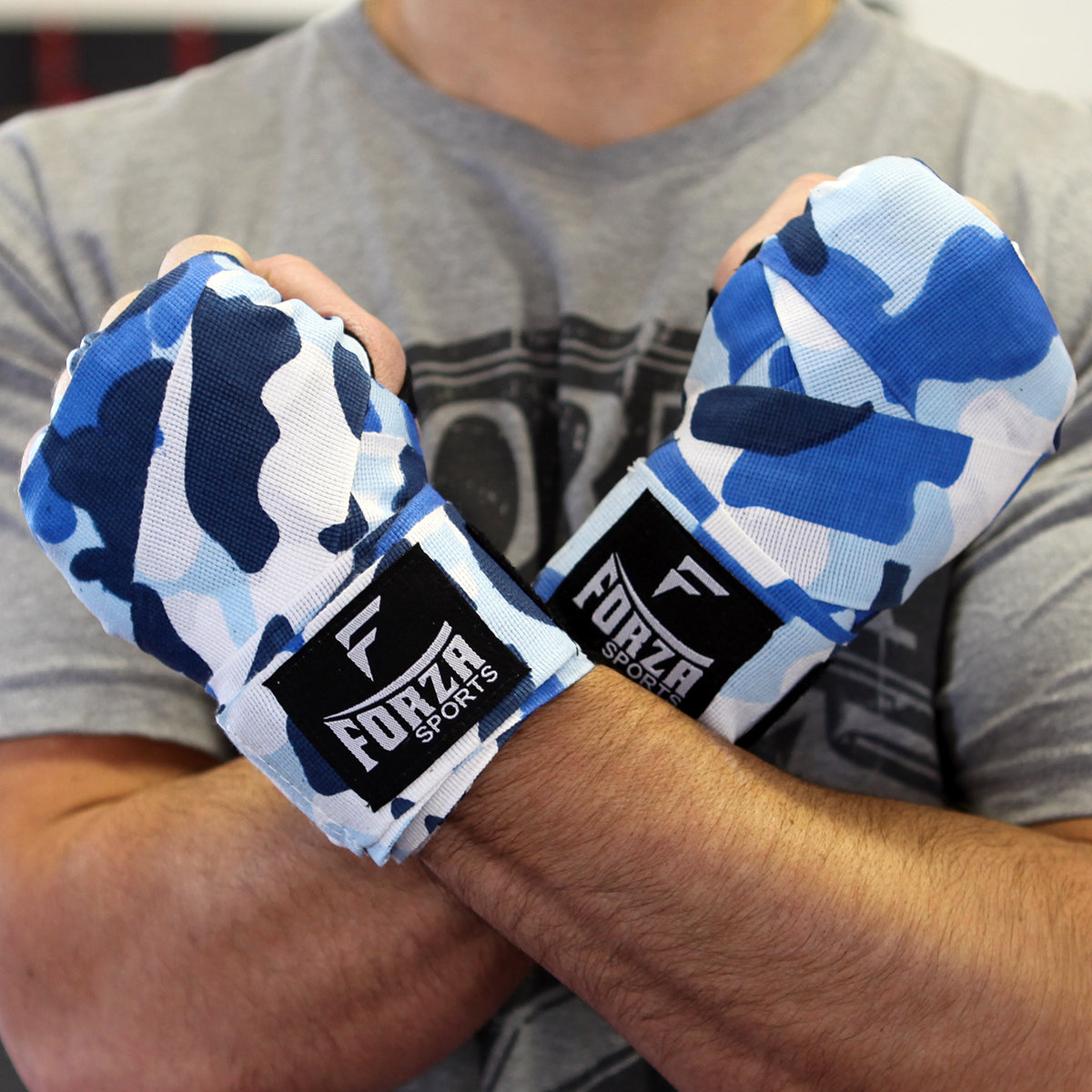 Person wearing blue and white camouflage boxing hand wraps with 'Forza Sports' branding.