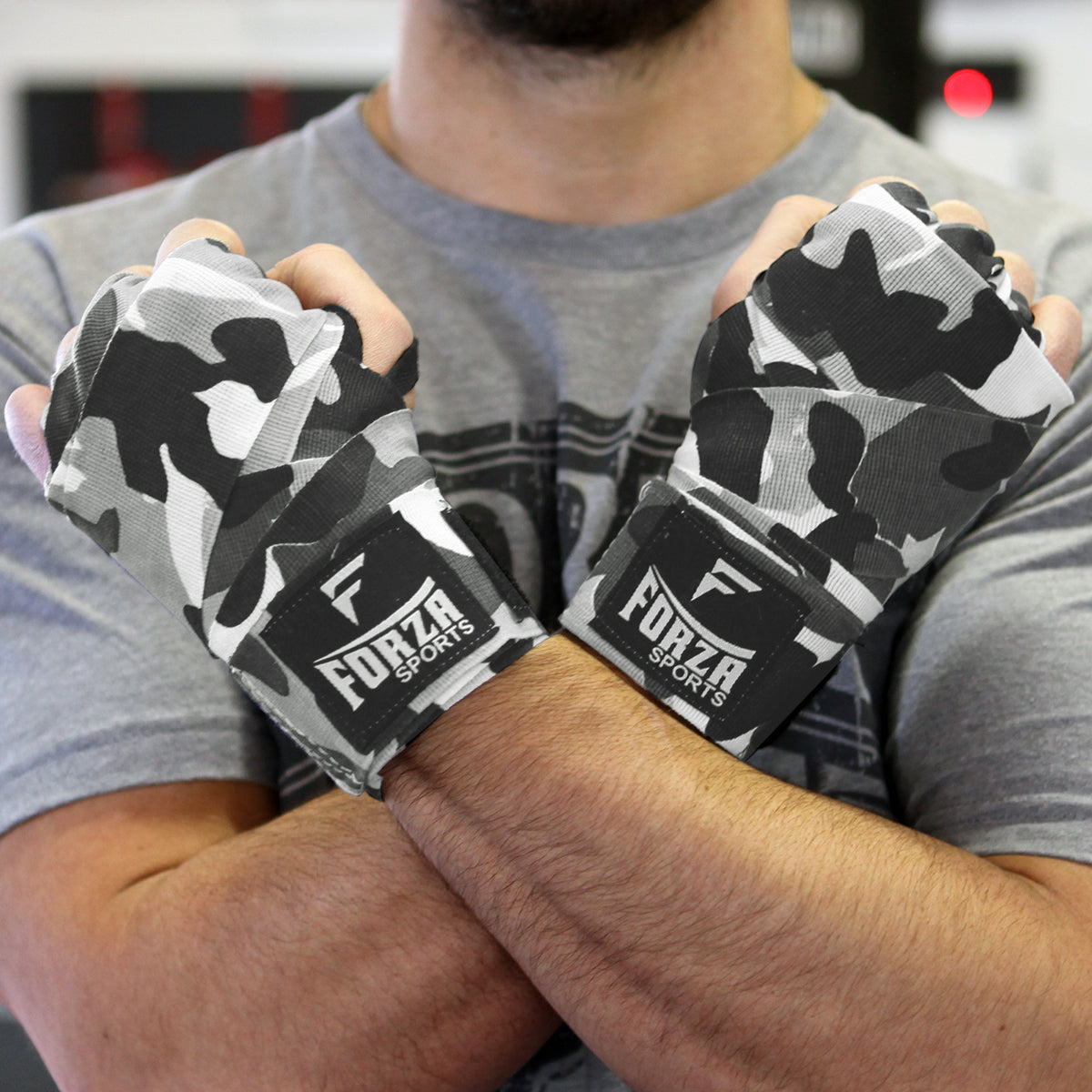 Person wearing camouflage boxing hand wraps with Forza Sports logo.