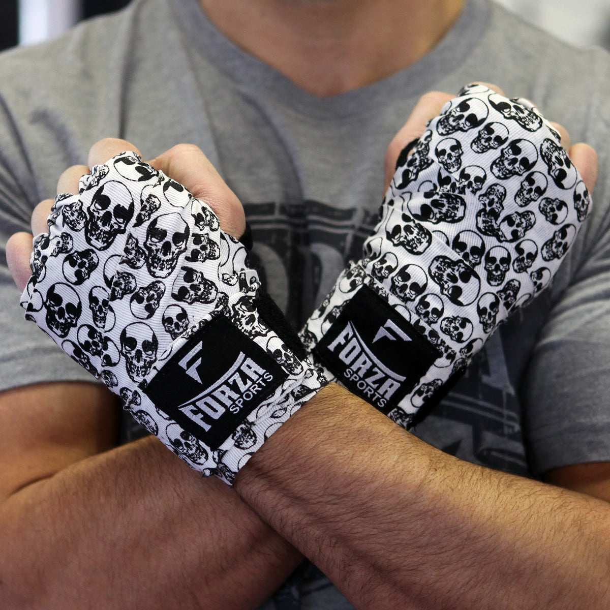 Person wearing boxing wraps with skull pattern and Forza Sports branding.