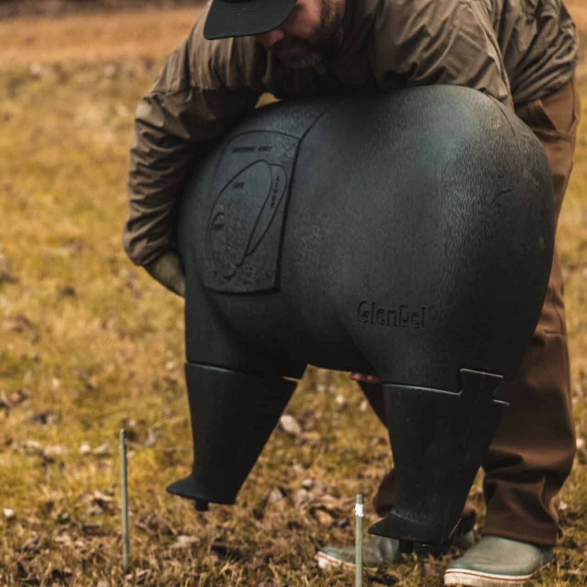 Person holding a black 3d bear archery target bag with 'GlenEagle' branding in an outdoor setting.