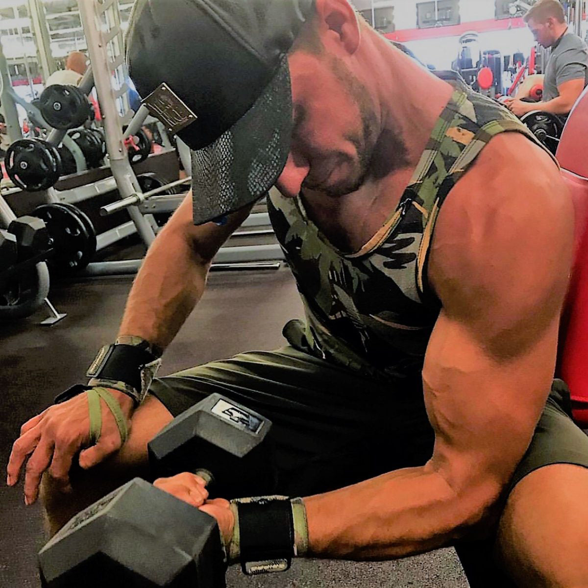 Muscular man exercising with dumbbells in a gym setting