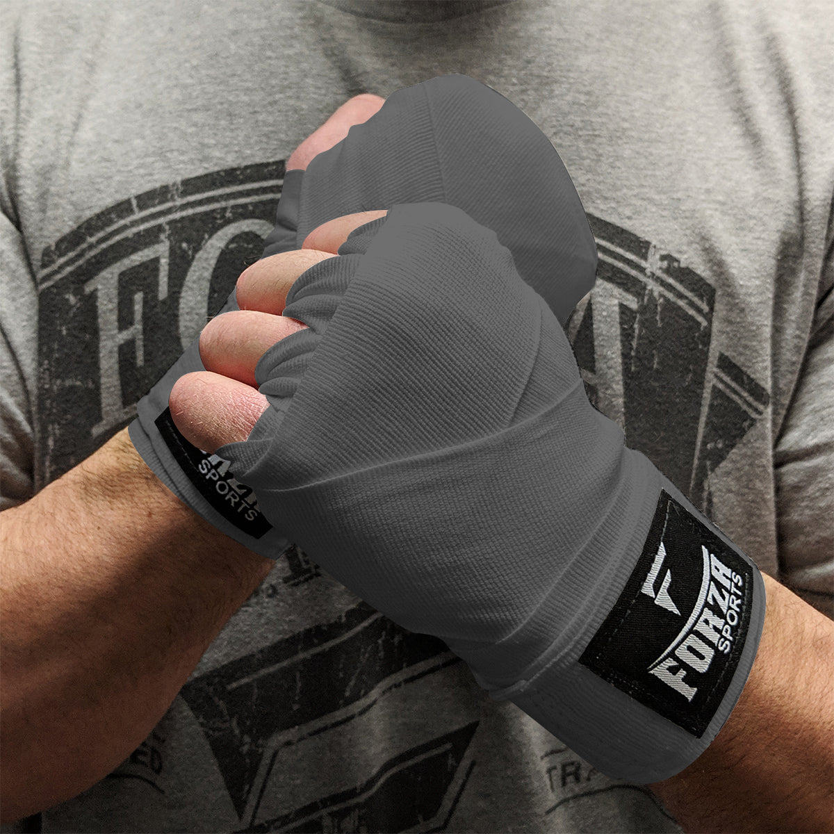 Person wearing gray boxing hand wraps with Forte Sports logo, holding a fist.