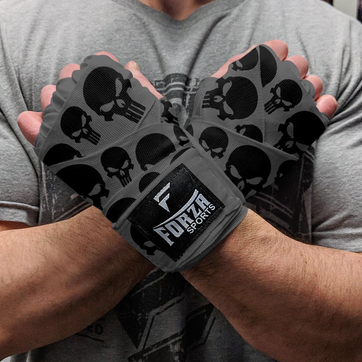 Person wearing gray wrist wraps with black skull patterns and Forza Sports logo.