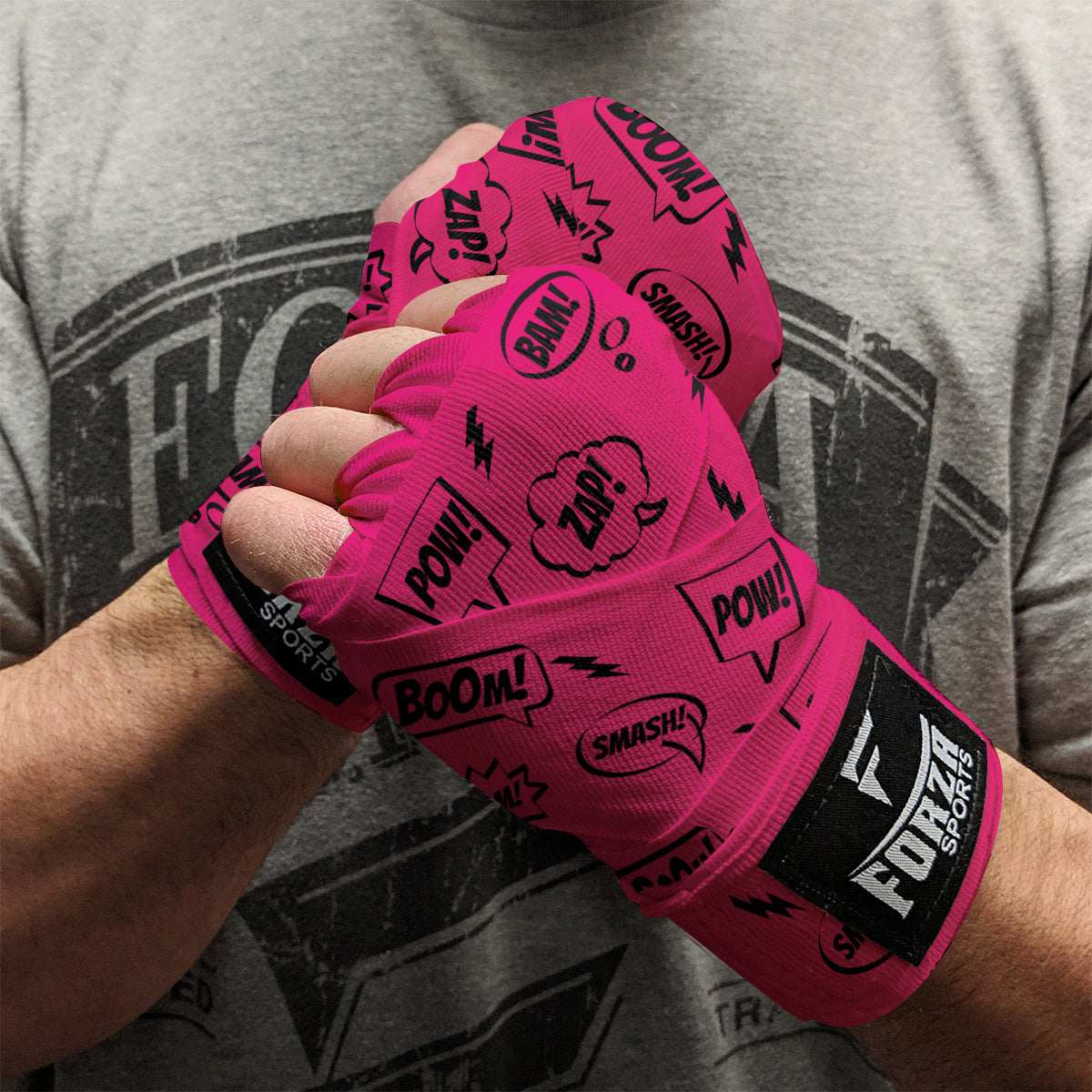 Person wearing pink boxing hand wraps with text design, branded 'Forte Sports', against a gray t-shirt background.