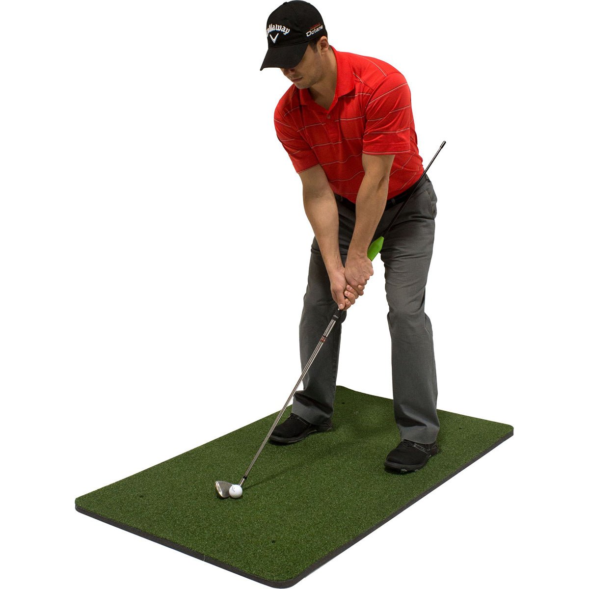 Man practicing golf training aid swing on a green mat with a white background