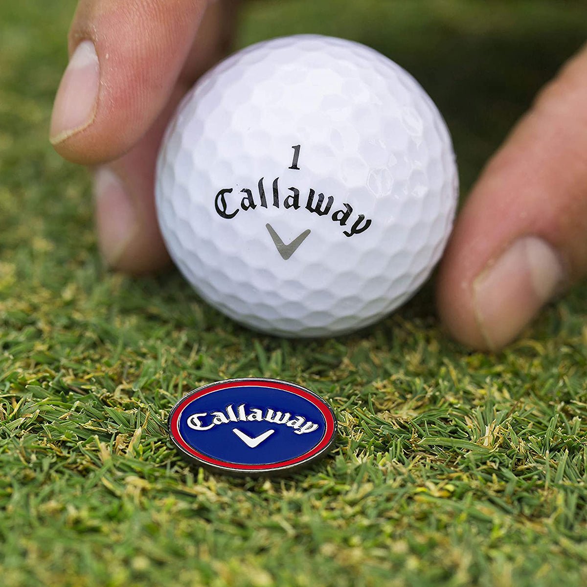Callaway golf divot repair tool and ball marker on grass