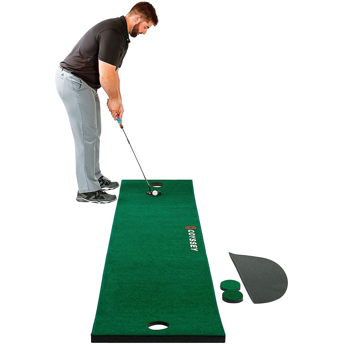 Man practicing golf on a green golf putting mat with a golf club and ball.