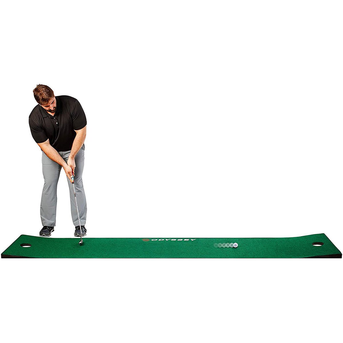 Man practicing golf swings on a green golf putting mat with a white background