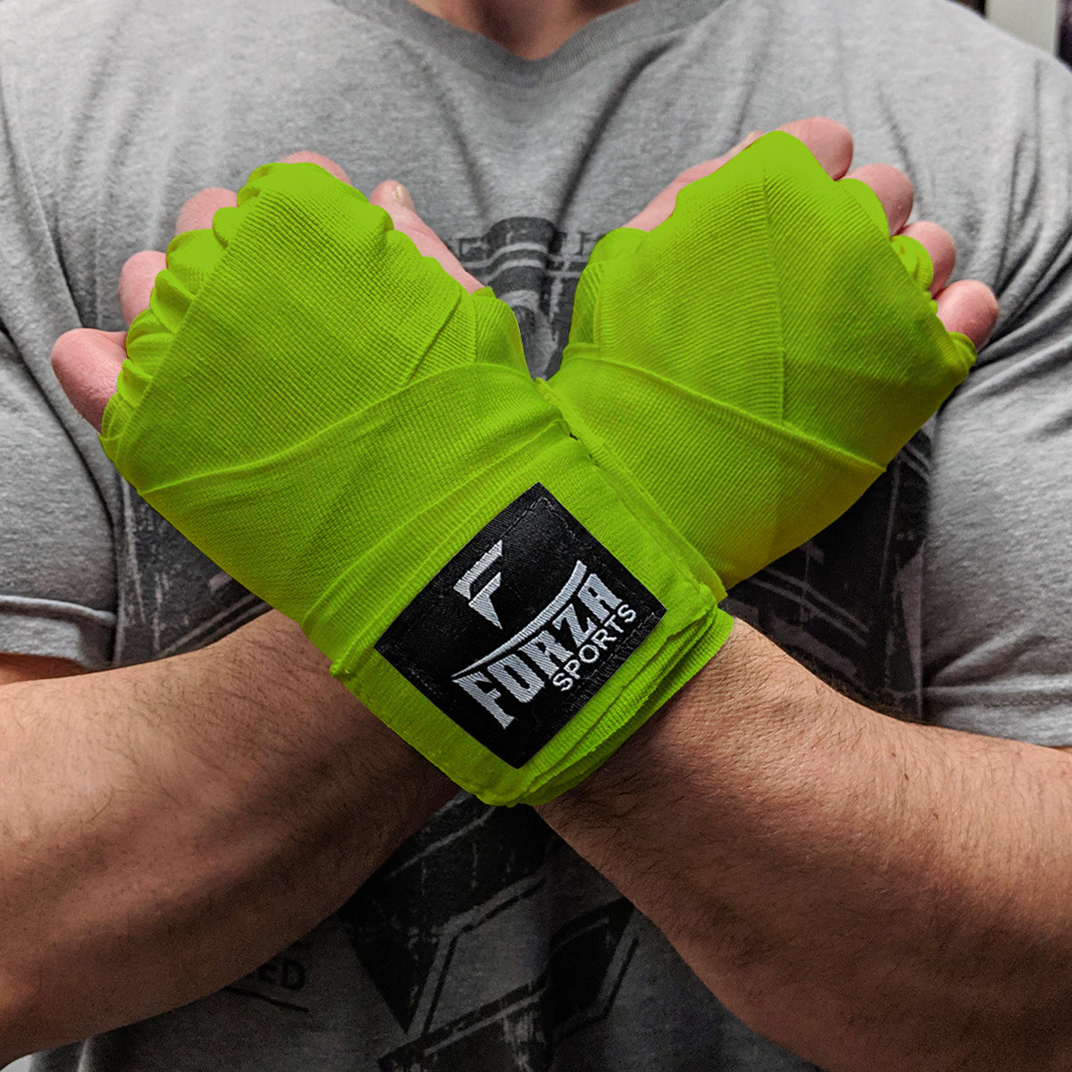 Person wearing bright green boxing wraps with a visible brand logo on a gray background