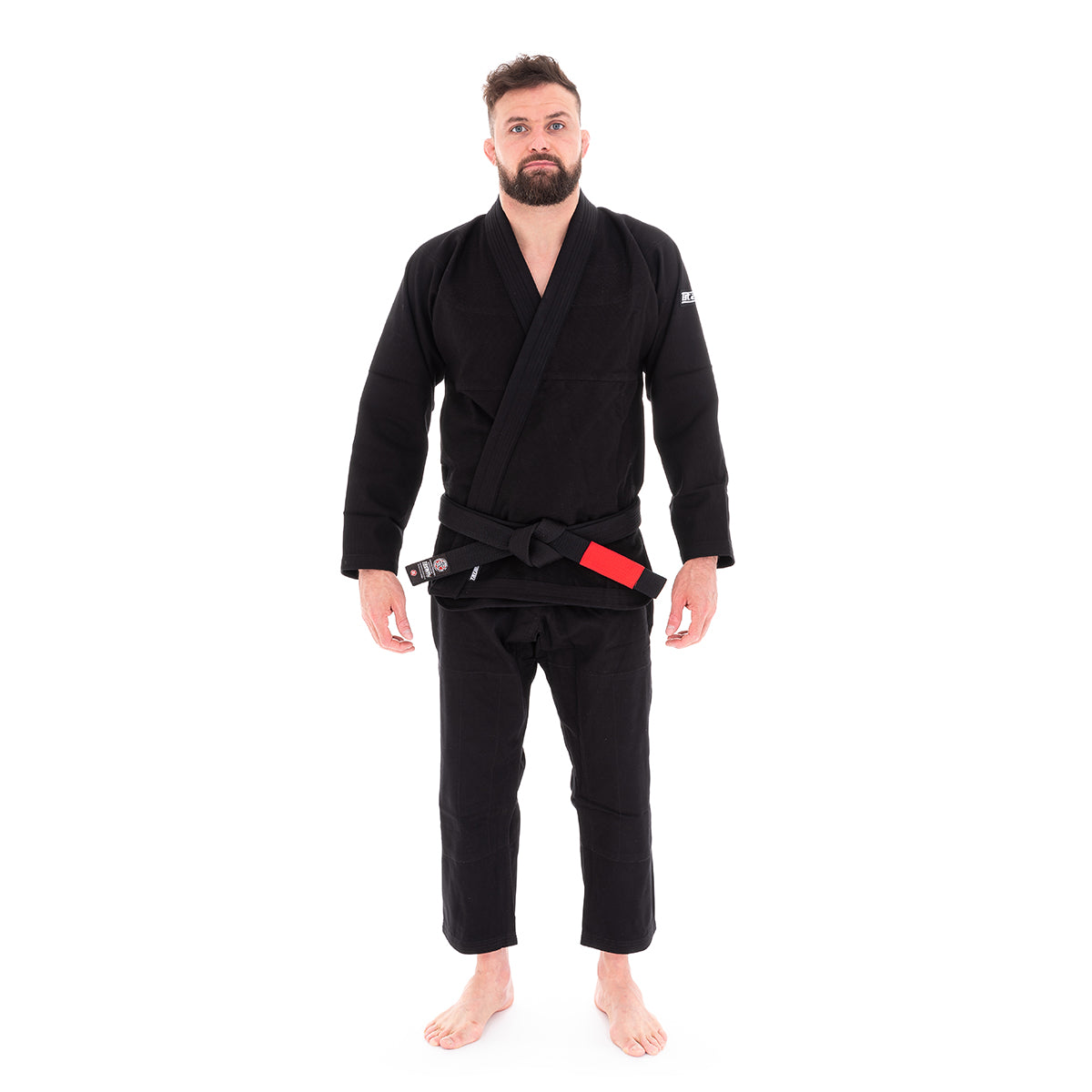 Man wearing a black martial arts uniform with a red belt on a white background