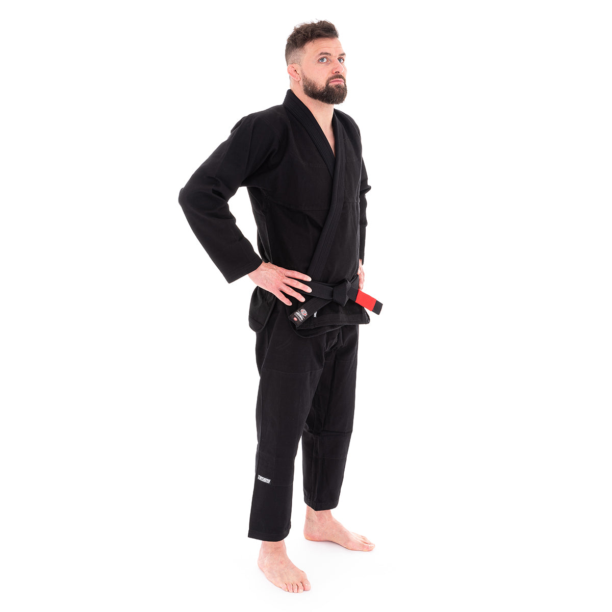 Man wearing a black martial arts gi on a white background
