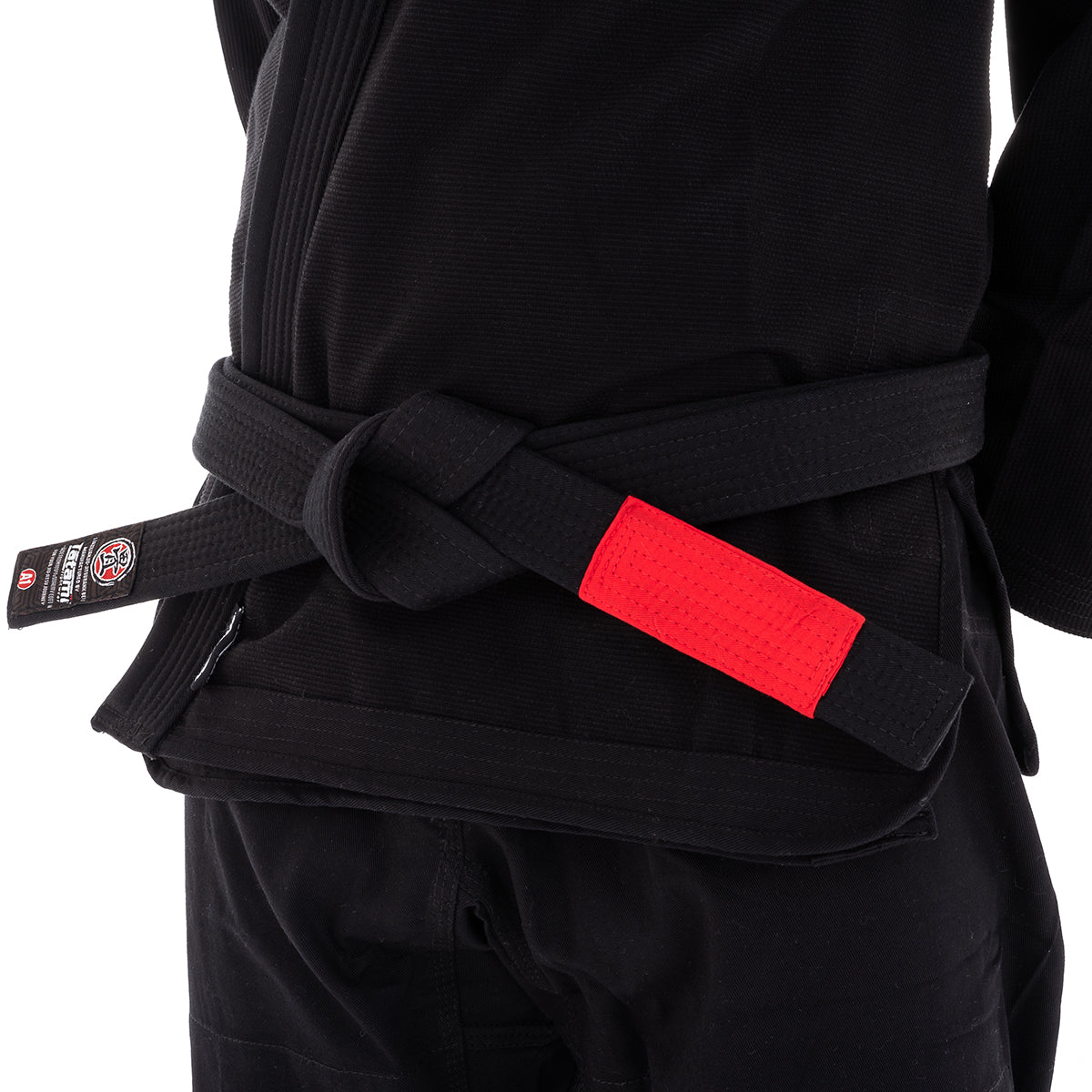 Black martial arts gi with a red belt on a white background