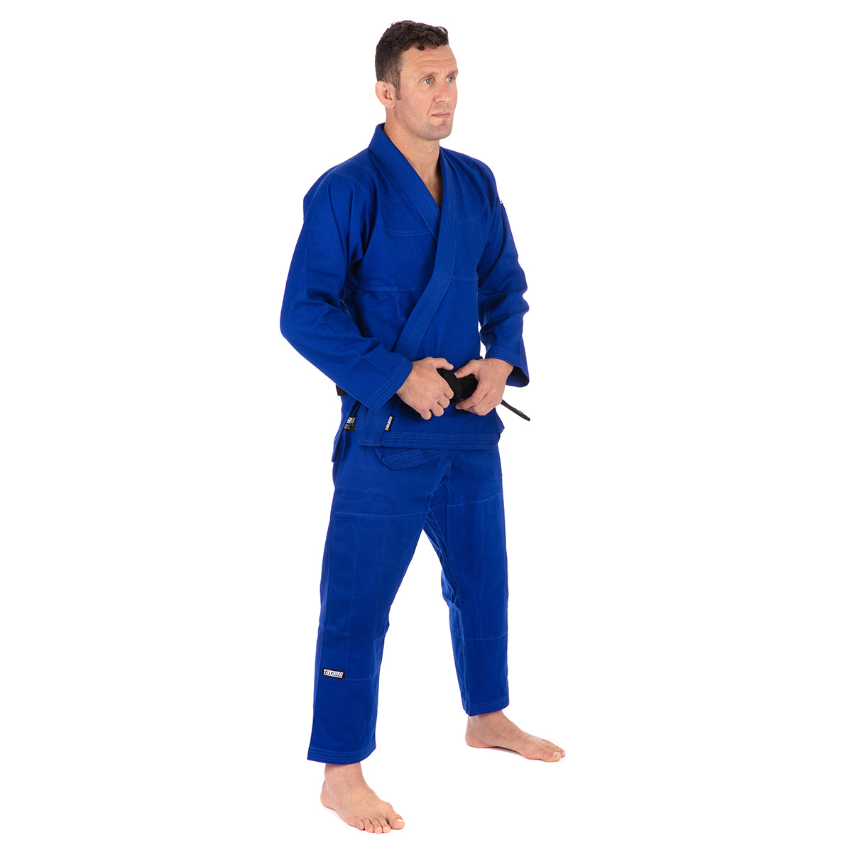 Man wearing a blue martial arts uniform on a white background