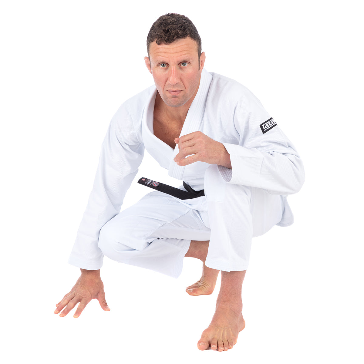 Man in a white martial arts uniform with a black belt on a white background