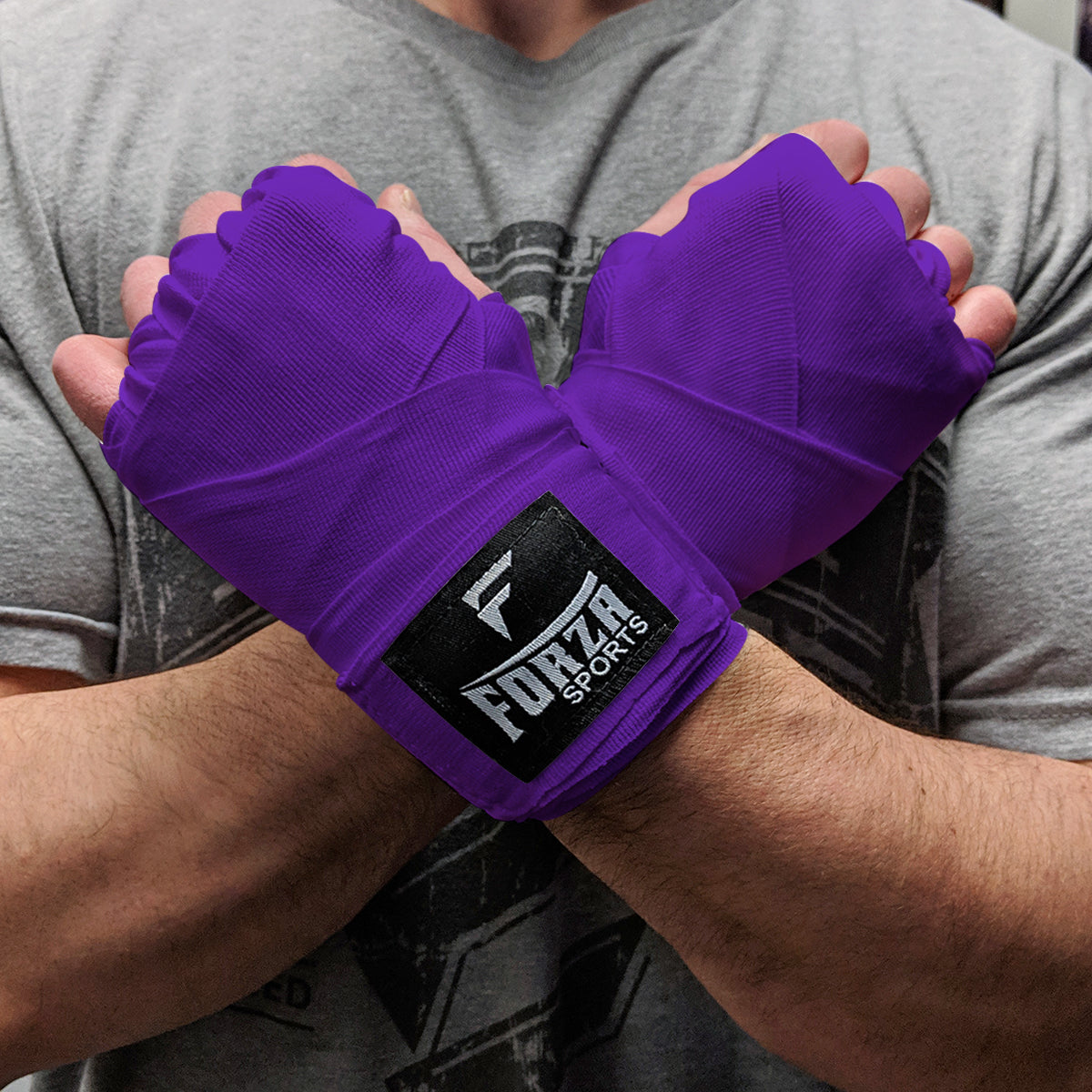 Person wearing purple boxing hand wraps with Forza Sports logo.