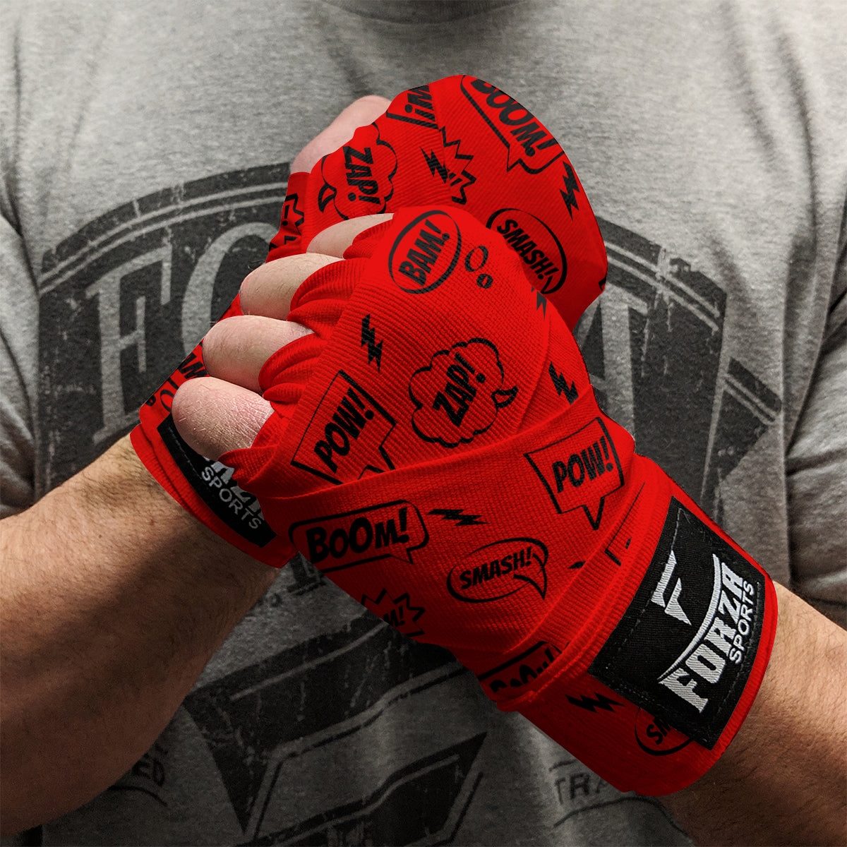 Red boxing hand wraps with black text and Fule logo worn by a person, against a gray t-shirt background.
