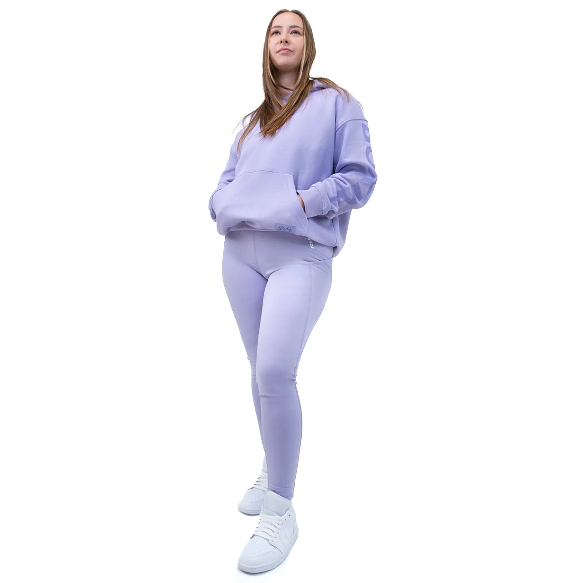 Woman wearing a light purple heavyweight fleece hoodie and leggings set on a white background