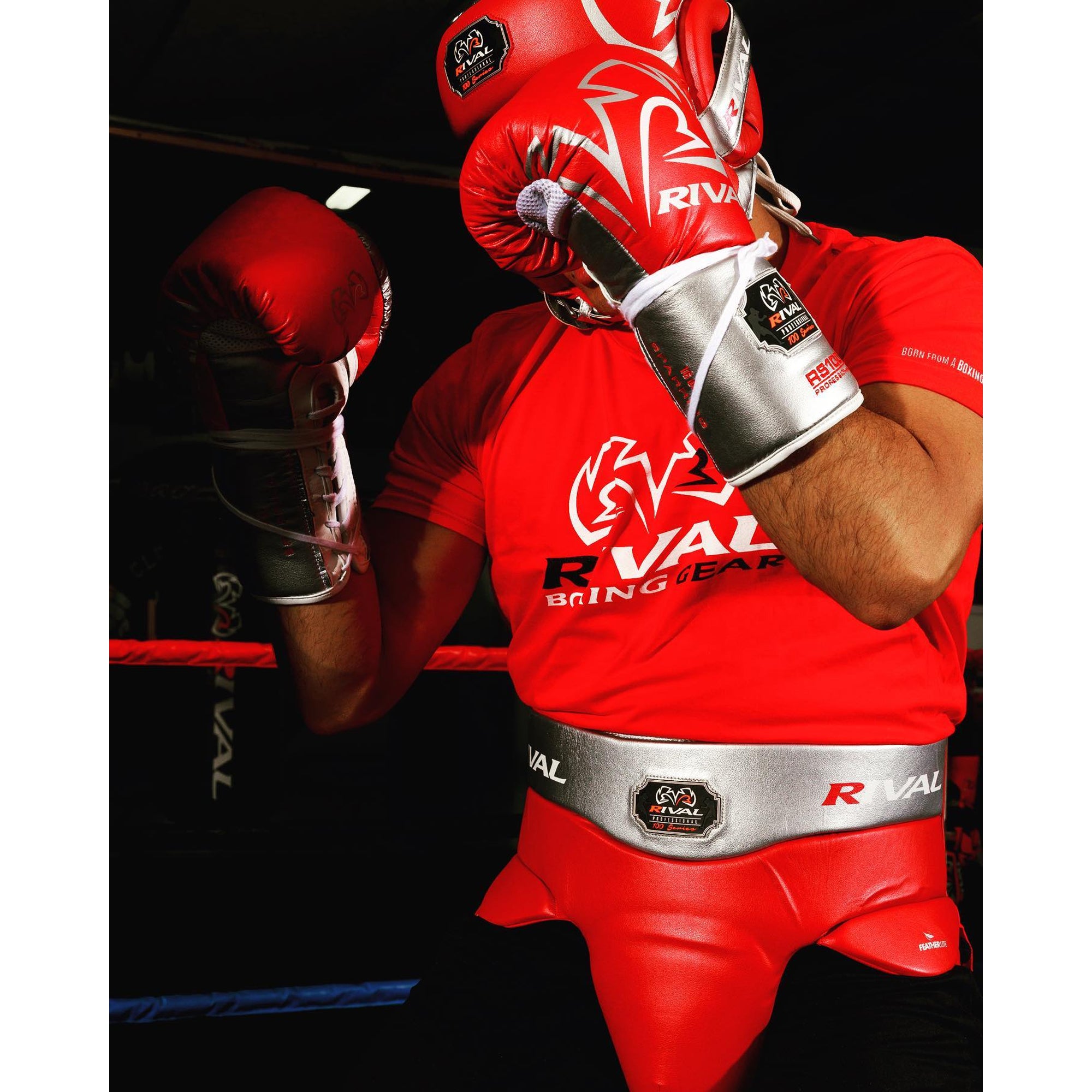 Boxer in red and white Rival boxing gear in a boxing ring.
