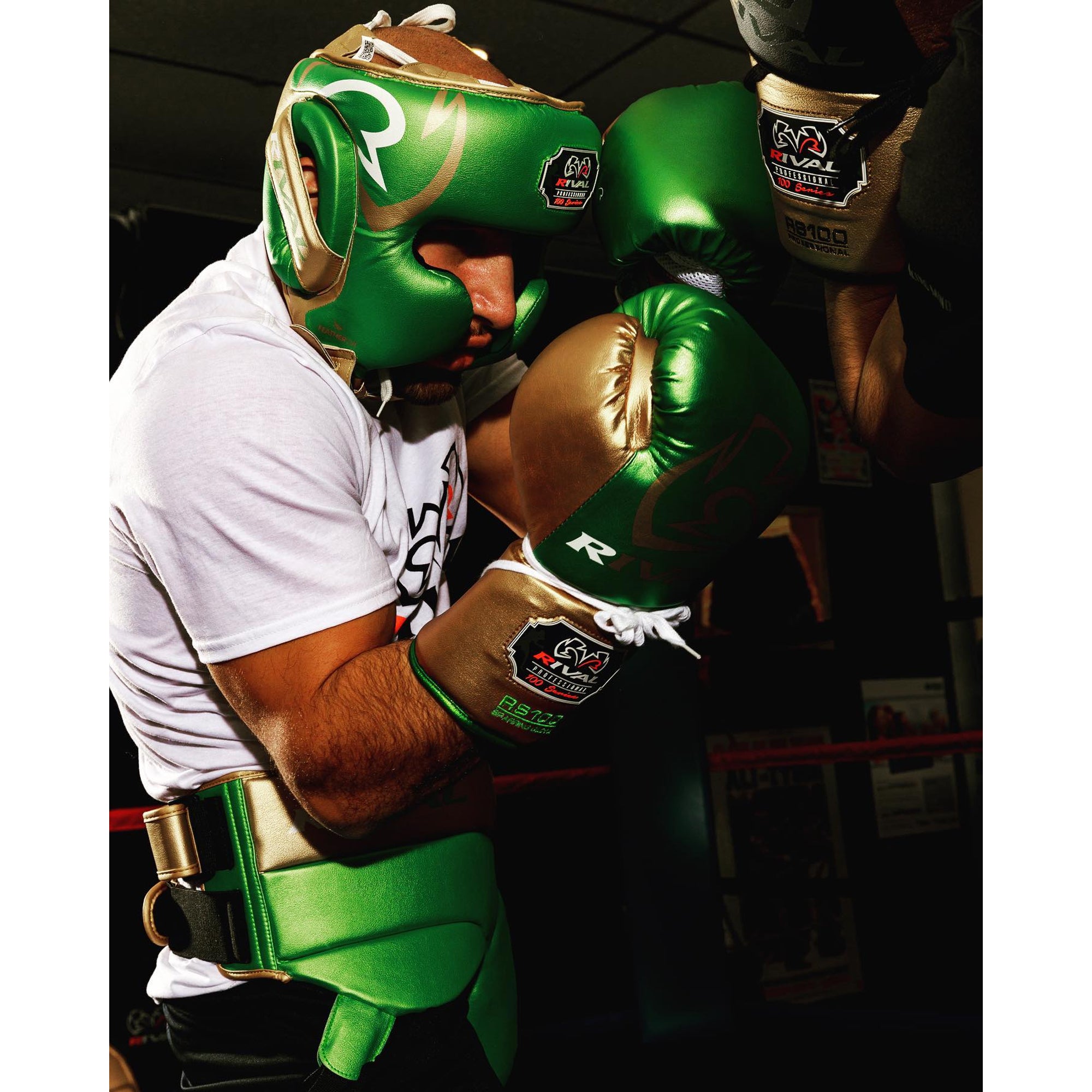 Person wearing green boxing gloves and headgear in a boxing ring.