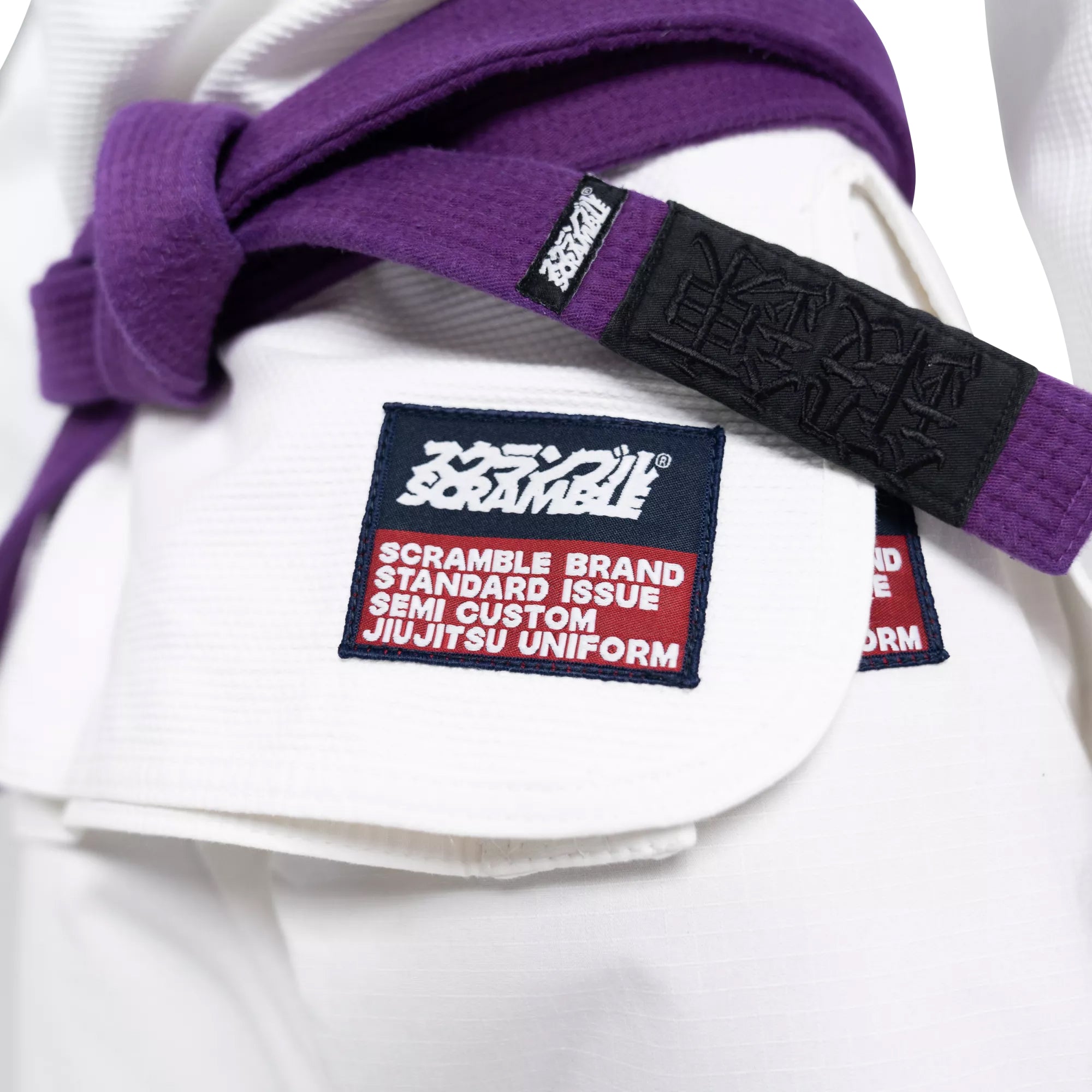 White jiu-jitsu uniform with purple belt and Scramble brand label on a white background