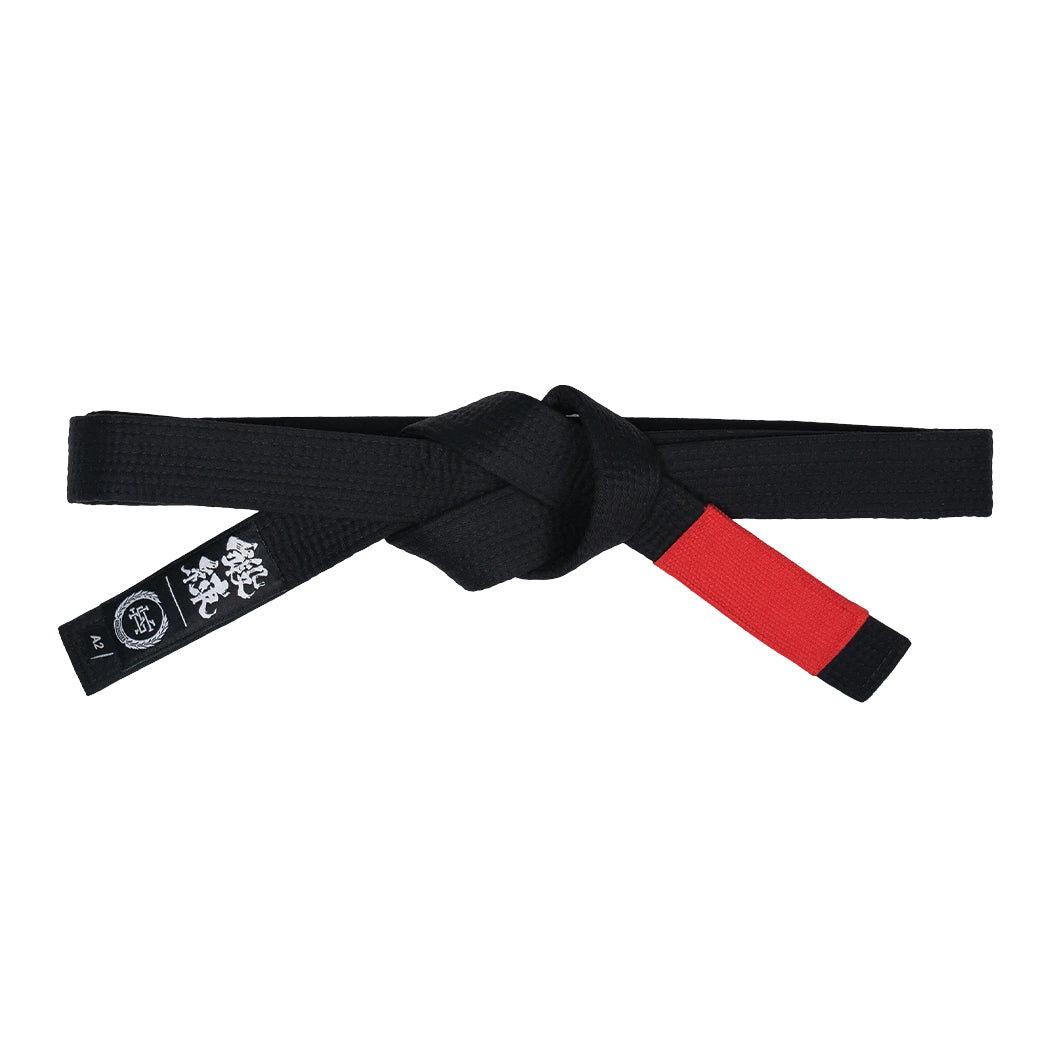 Black martial arts belt with a red end on a white background