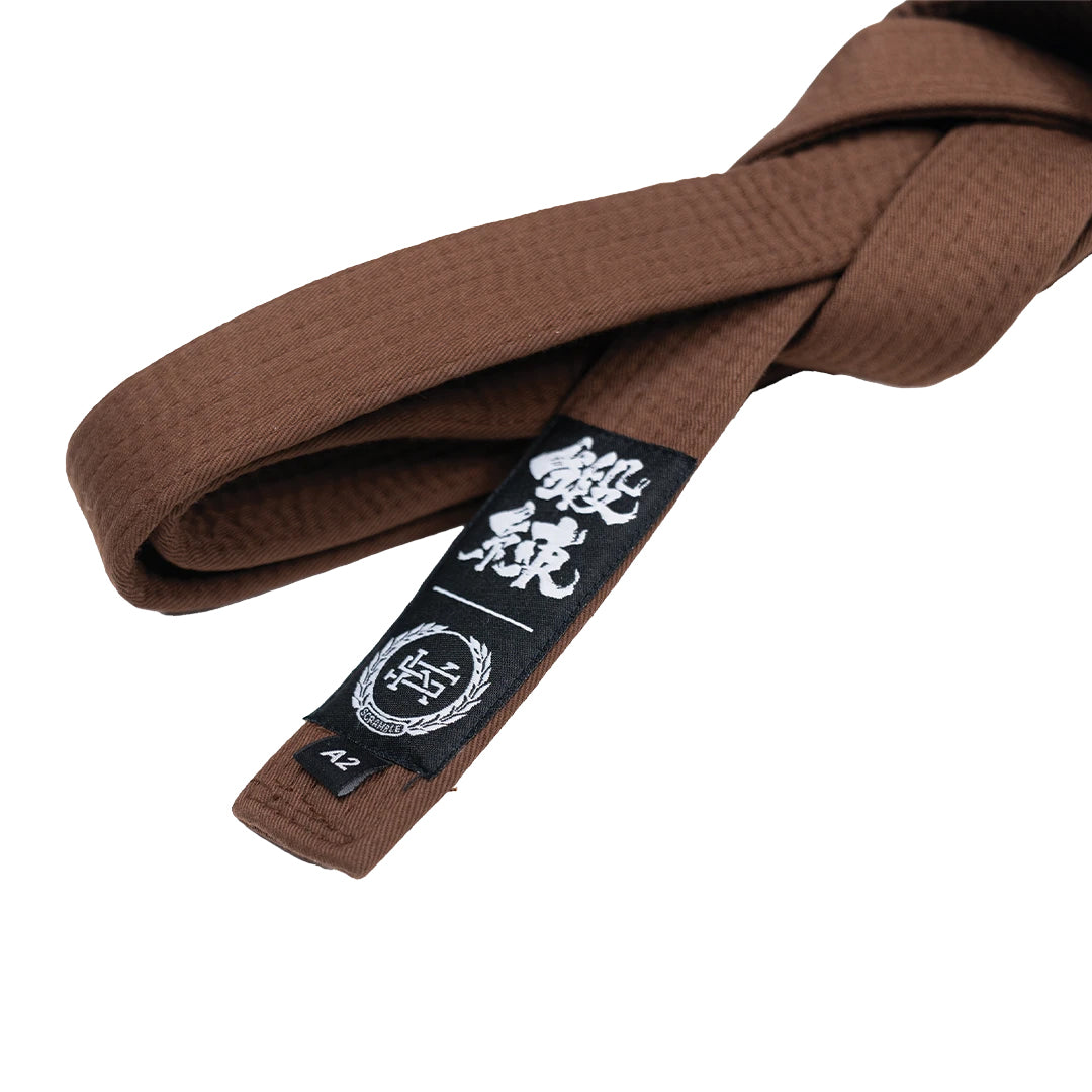 Brown martial arts belt with a black belt patch on a white background