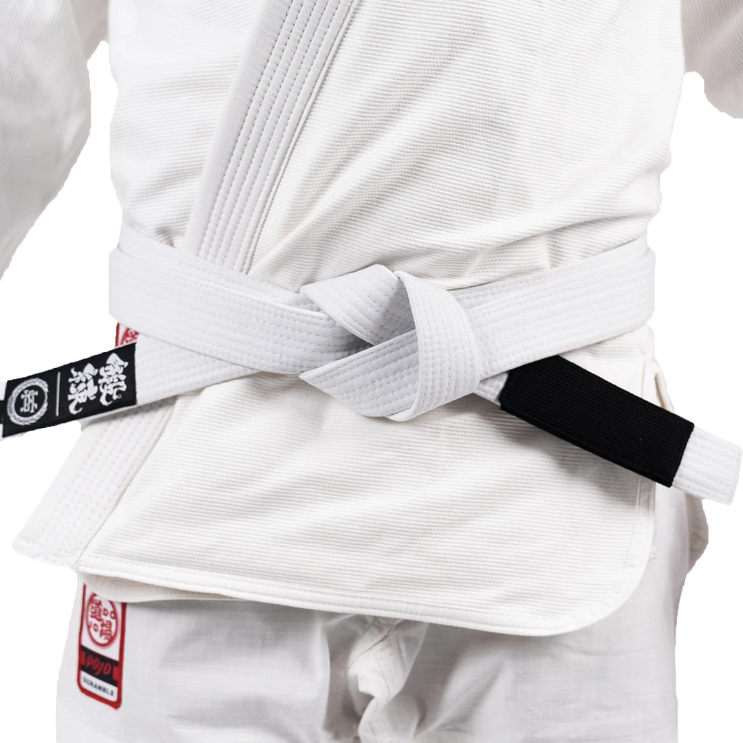 White martial arts uniform with a black belt and visible brand logos.