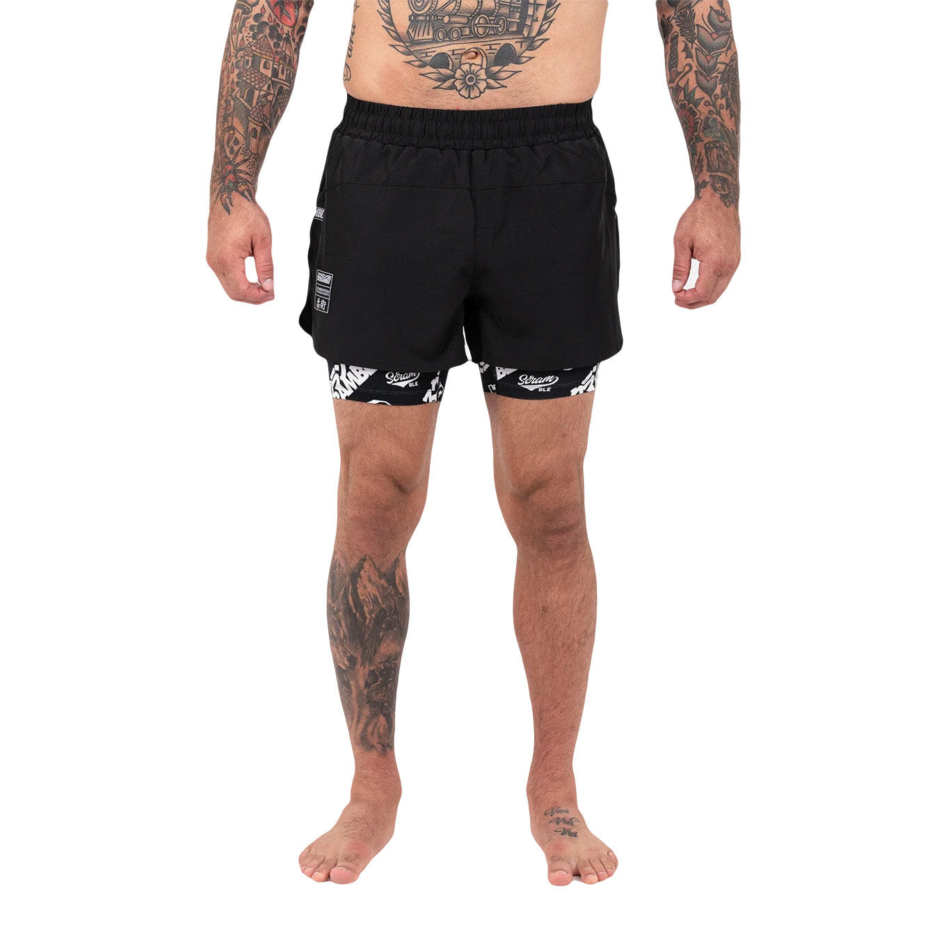 Person wearing black swim shorts with white patterns on a white background