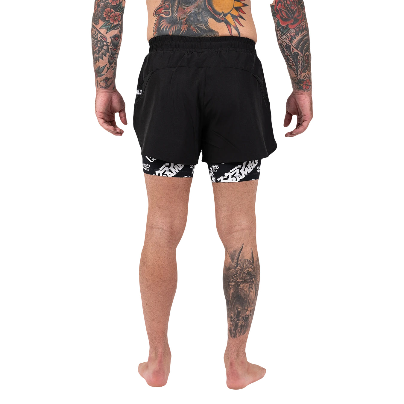 Person wearing black shorts with white patterns on a white background