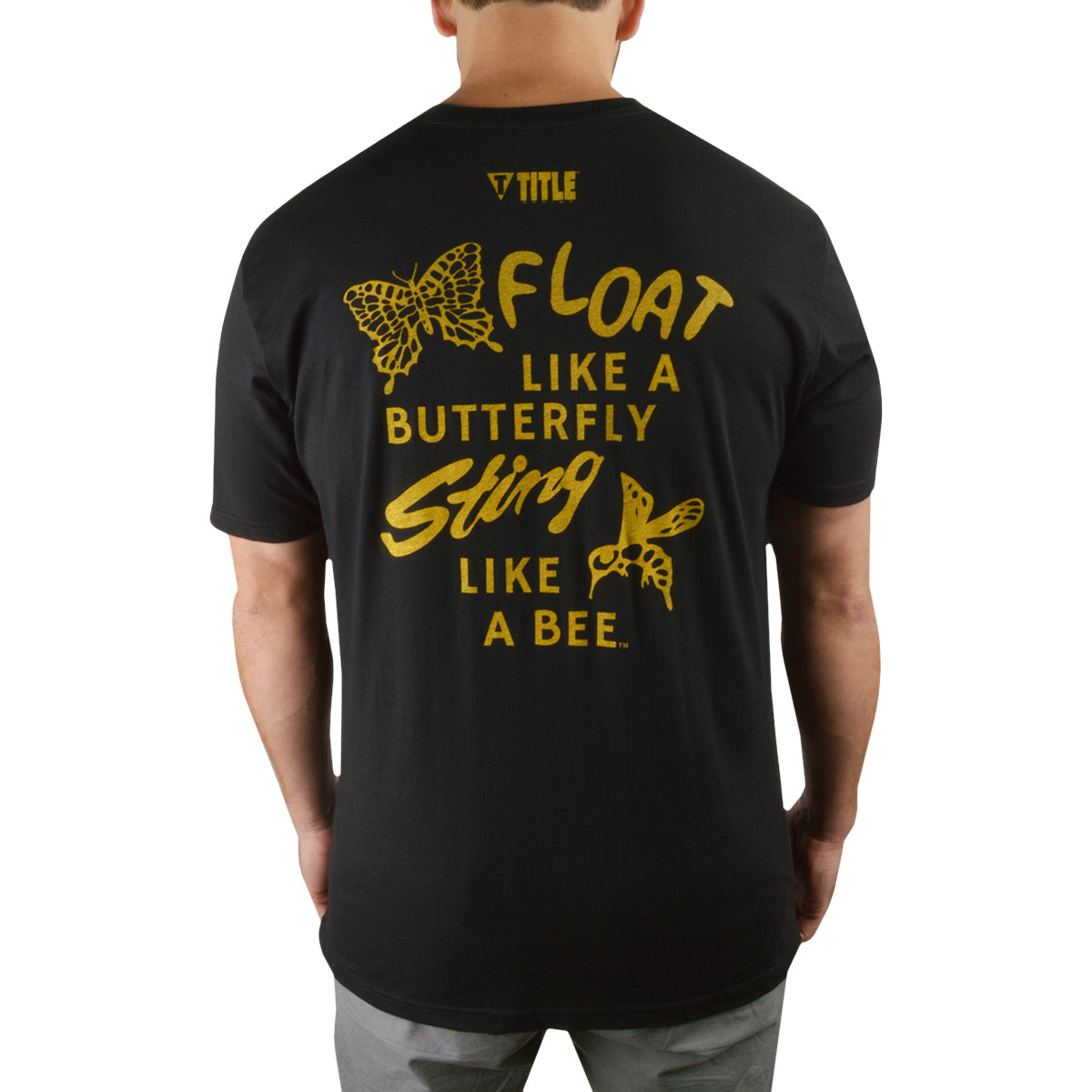 Black t-shirt with yellow text and butterfly graphics on the back, worn by a person.