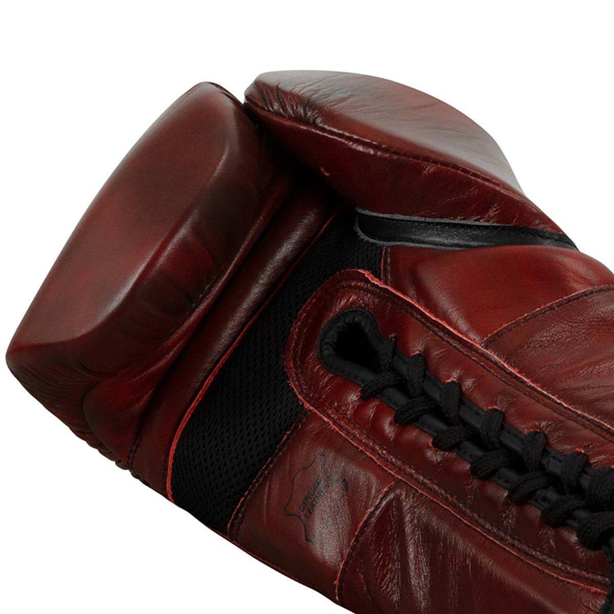 Close-up of a brown leather boxing glove with black stitching on a white background