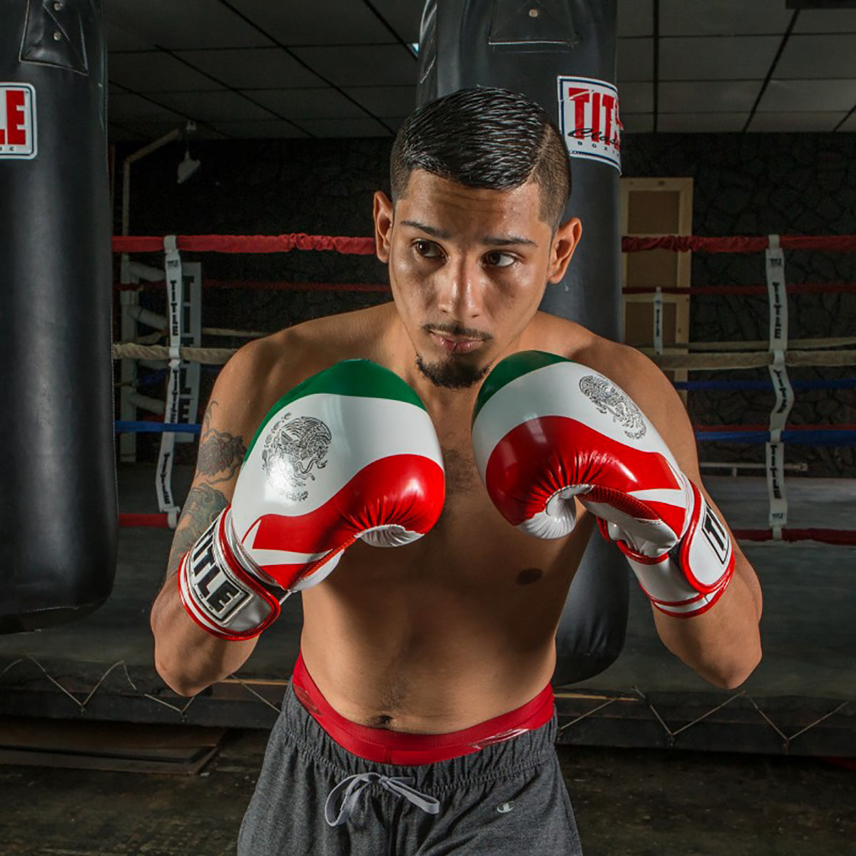 Boxer in a gym wearing Title Boxing Infused Foam El Combate Mexico Hook and Loop Training Gloves