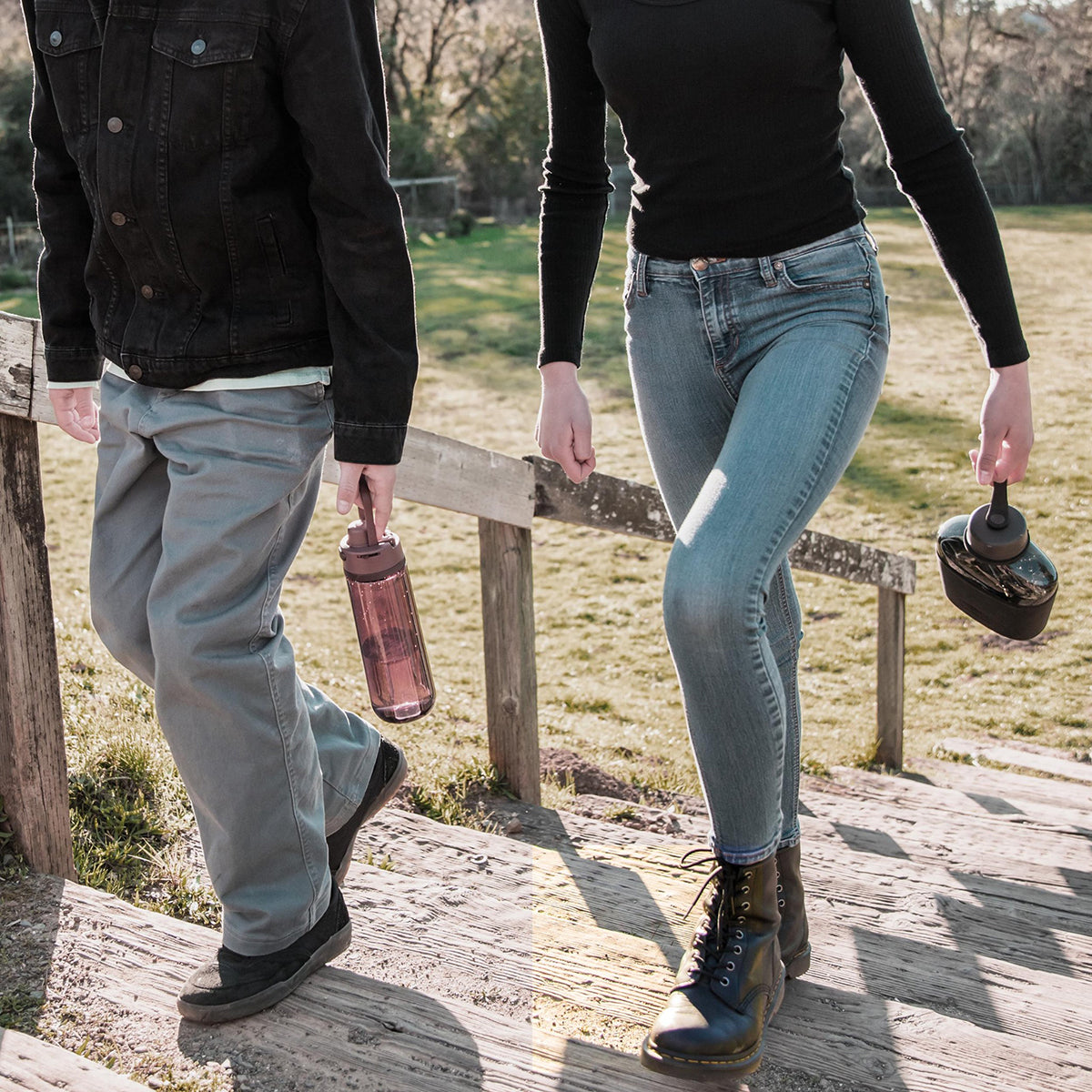 Two people walking on a wooden path with a scenic background