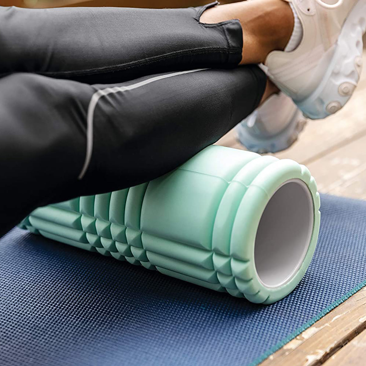 Person using a mint foam roller myofascial release by TriggerPoint