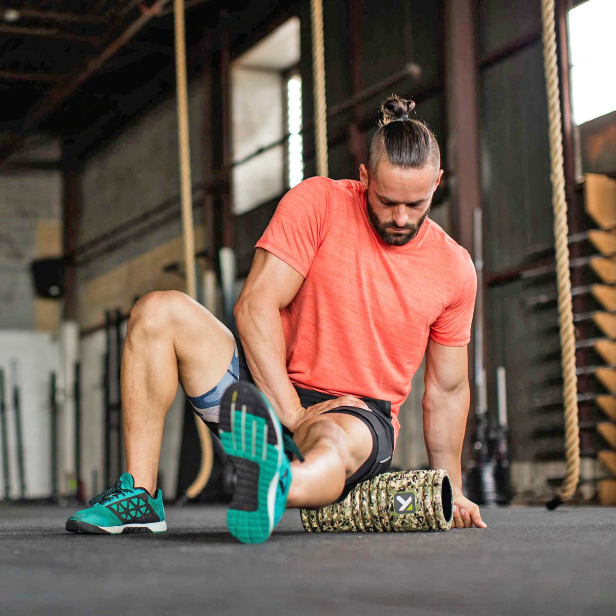 Man in a gym using a portable massage roller - Forza Sports