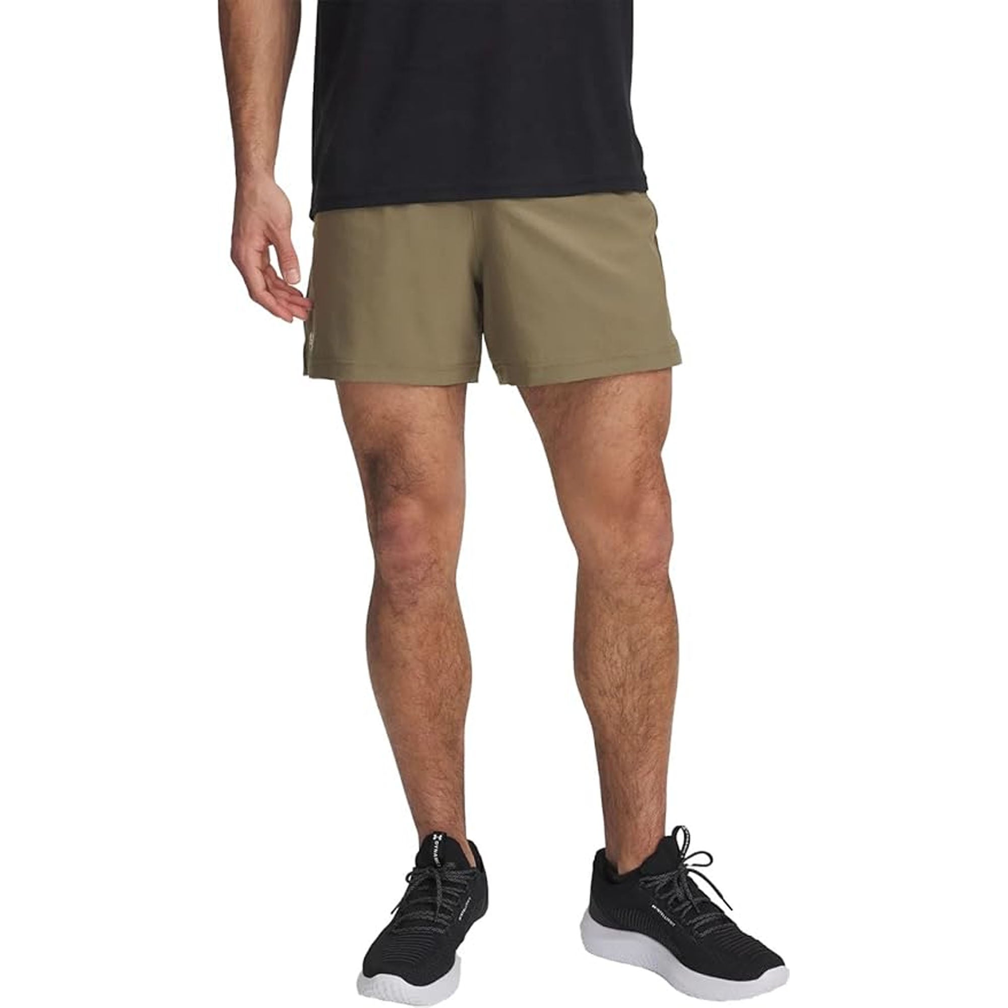 Person wearing khaki woven shorts and black sneakers on a white background