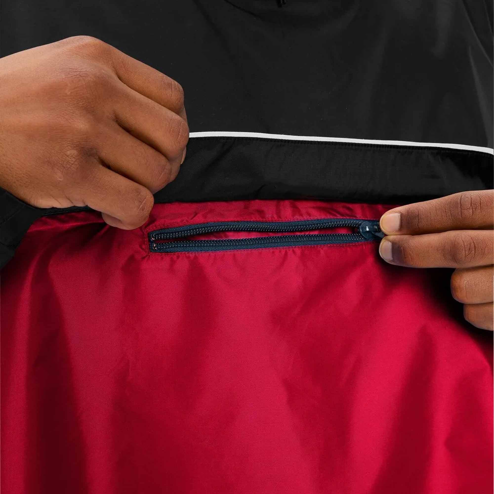 Person zipping a black and red jacket