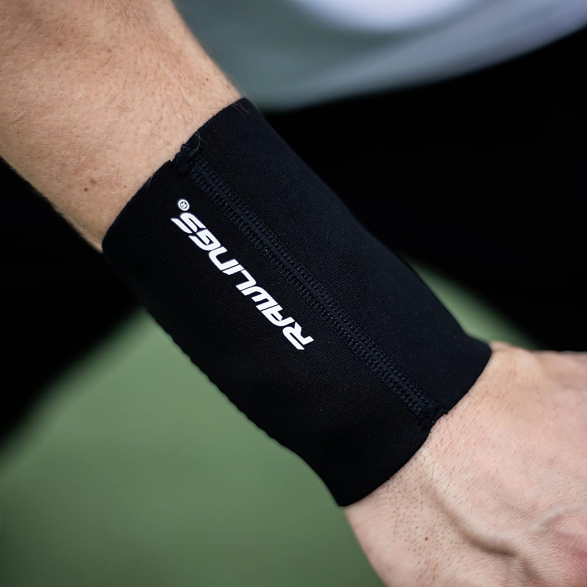 Black wrist support brace with 'Ravuss' branding on a blurred background
