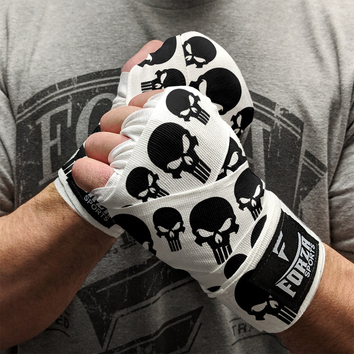 Person wearing white boxing gloves with black skull designs and F'URST Sports branding.