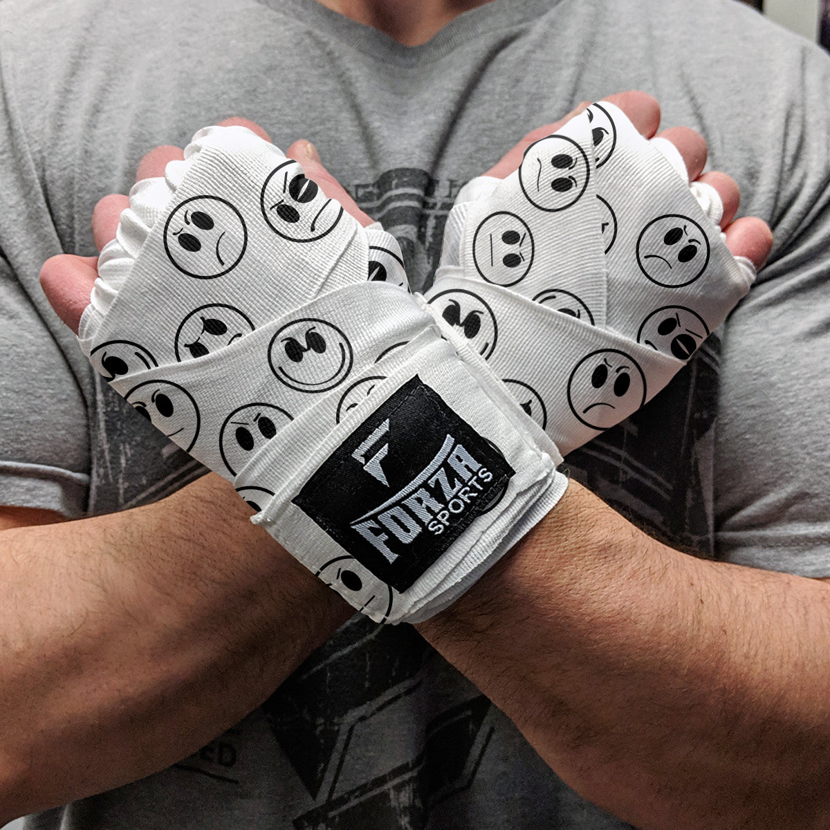 Person wearing white boxing wraps with black smiley face patterns and 'Furza Sports' branding.