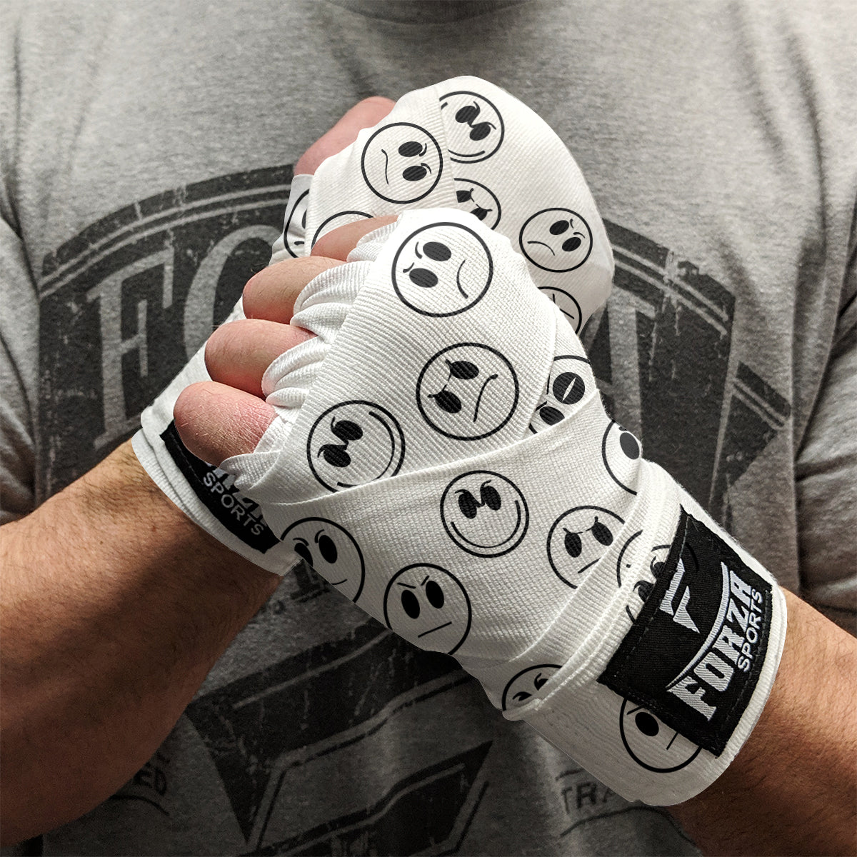Person wearing white boxing gloves with black smiley face patterns, holding fists together.
