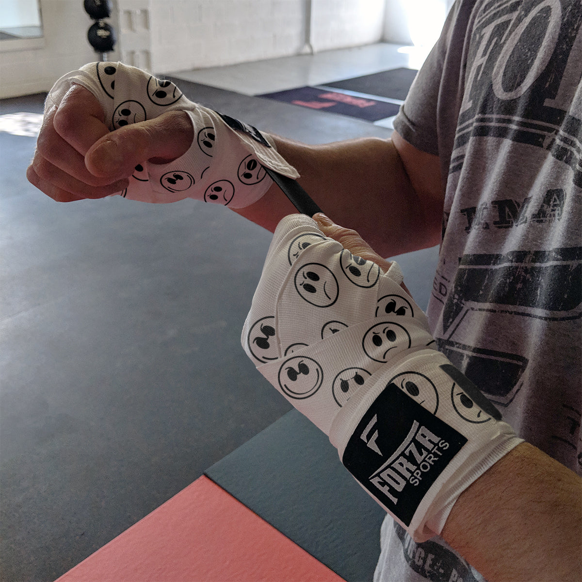 Person wearing boxing wraps with a visible brand logo in a gym setting