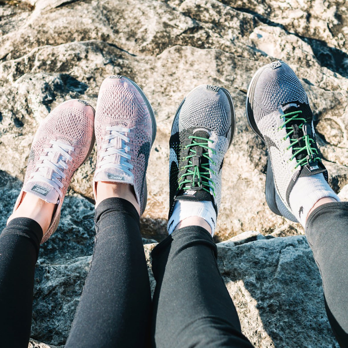Person wearing four different types of athletic shoes on a rocky surface