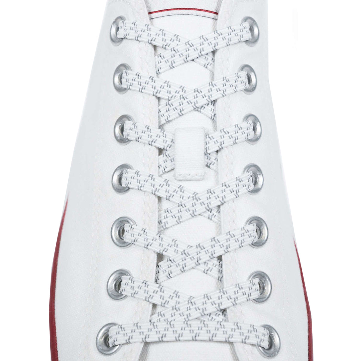 Close-up of white sneakers with red soles and laces on a white background