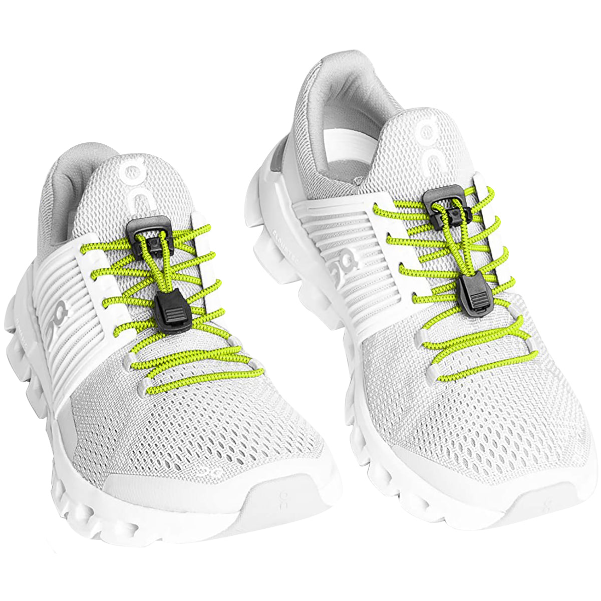 White and gray athletic shoes with bright green laces on a white background