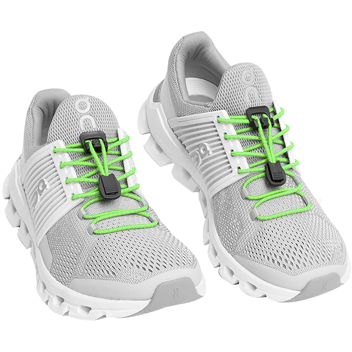 Gray athletic shoes with green laces on a white background